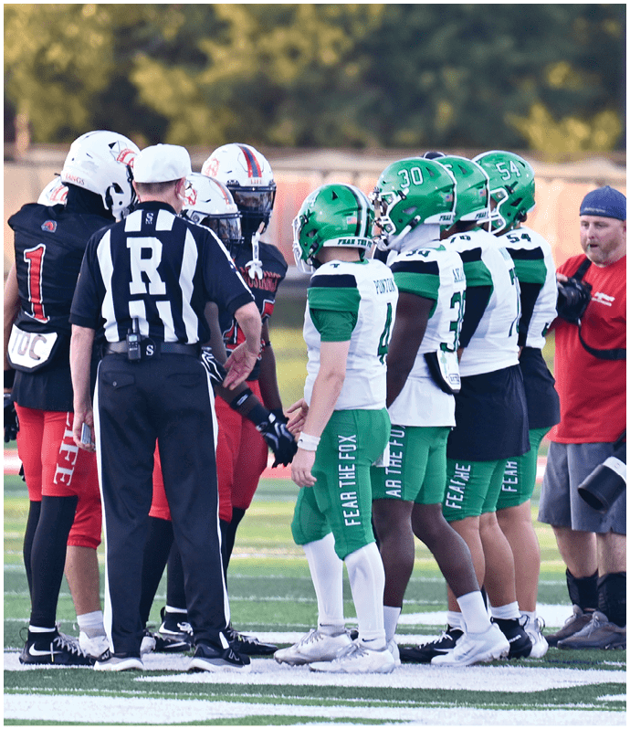 A group of football players in green and white uniforms and a referee in a black and white striped shirt are gathered on a field during a game. Descripci n generada con IA