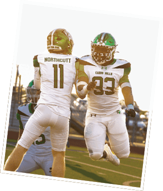 Two football players in white and green uniforms jump and celebrate on a field during a game at sunset. Descripci n generada con IA