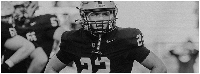 A football player wearing a blue and white uniform. Description generated by AI