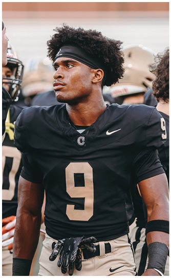 A football player catching a ball. Description generated by AI