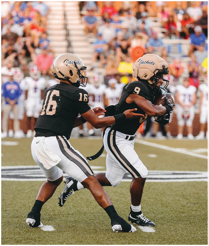 A group of football players wearing black and white uniforms. Description generated by AI