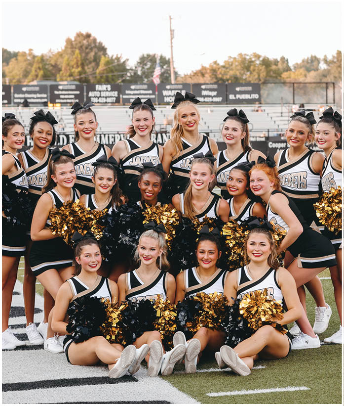 A group of football players wearing black and white uniforms. Description generated by AI