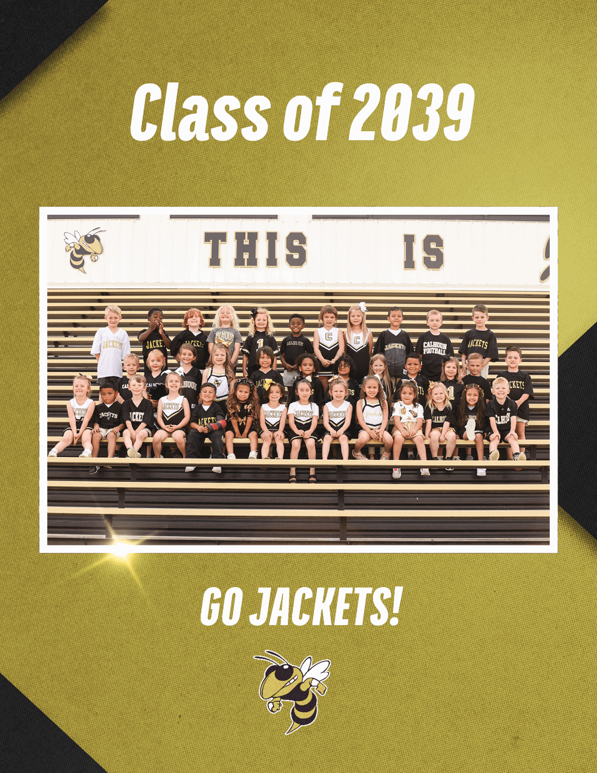 A group of children wearing school spirit clothing is seated on bleachers under a sign that reads “THIS IS" with text above and below the photo saying "Class of 2039" and "GO JACKETS!" along with a yellow jacket mascot illustration. Description generated by AI