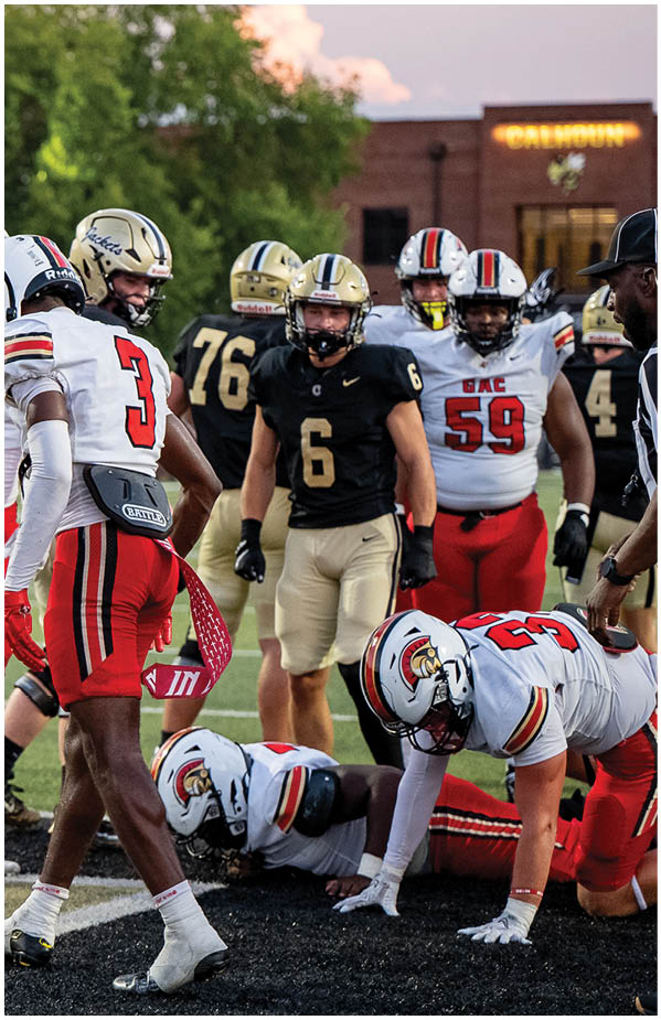 A group of football players wearing black and white uniforms. Description generated by AI