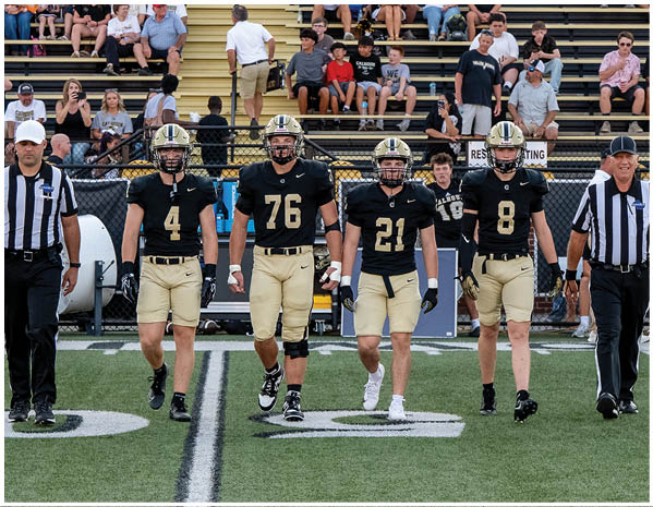 A group of football players on a field. Description generated by AI