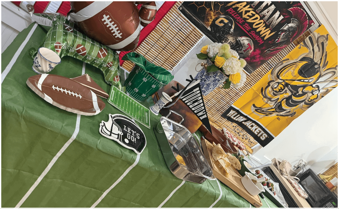 A group of people sitting and standing around tables in a room with a “Seniors Class of 2023" banner, eating and socializing. Description generated by AI