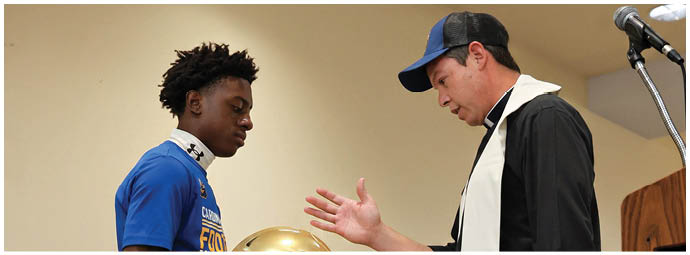 A football player wearing a blue and white uniform. Description generated by AI