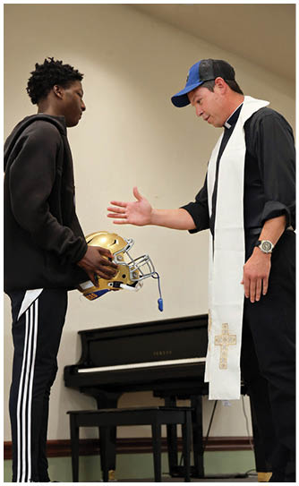 A football player catching a ball. Description generated by AI