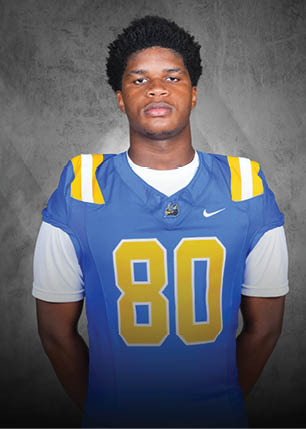 A young man wearing a white and black jersey with the number 14 on it. Description generated by AI