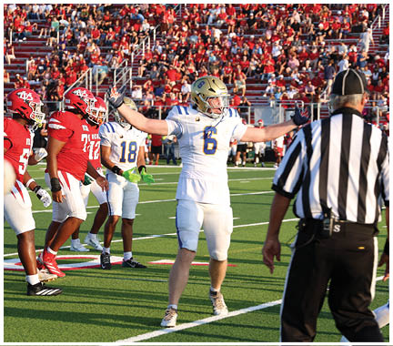 A football player wearing a blue and white uniform. Description generated by AI