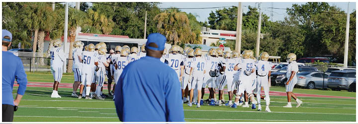 A group of football players on a field. Description generated by AI