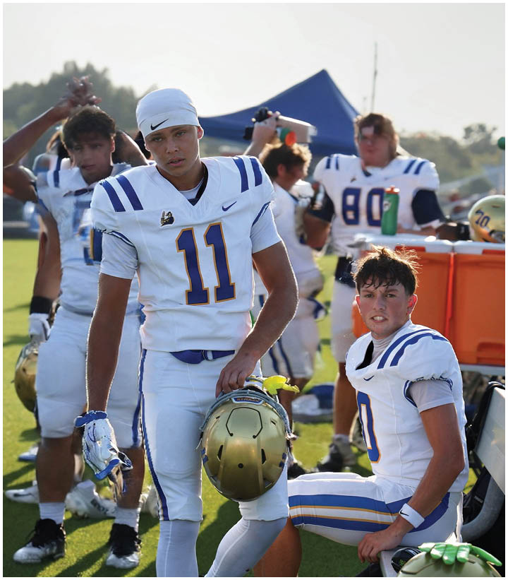 A group of football players wearing black and white uniforms. Description generated by AI