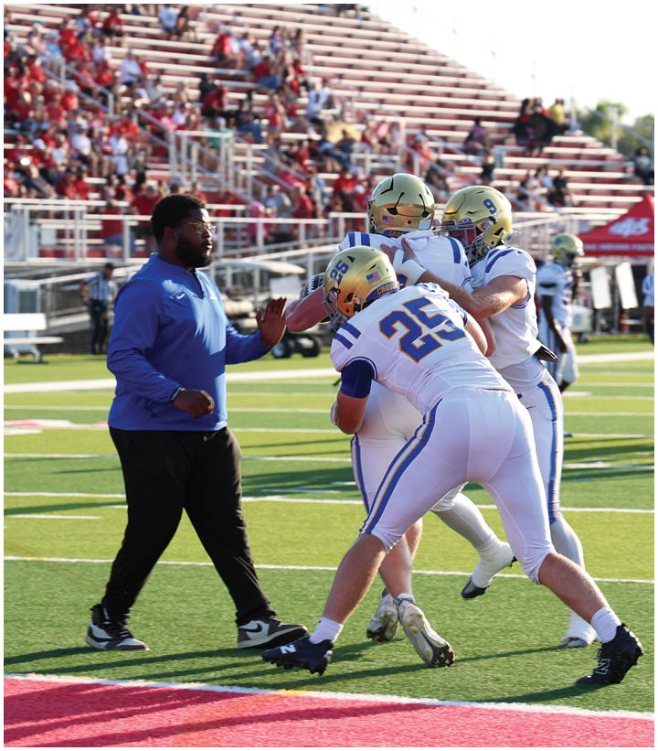 A group of football players wearing black and white uniforms. Description generated by AI