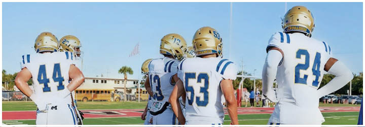 A group of football players on a field. Description generated by AI