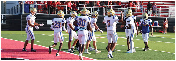 A group of football players on a field. Description generated by AI