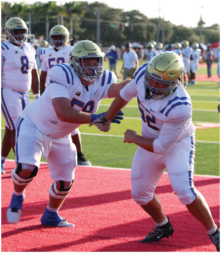 A group of football players wearing black and white uniforms. Description generated by AI