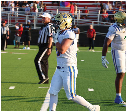 A football player wearing a blue and white uniform. Description generated by AI