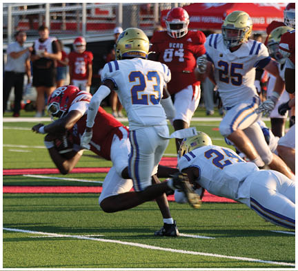 A group of football players huddled together on the field. Description generated by AI