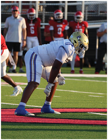 A football player wearing a blue and white uniform. Description generated by AI