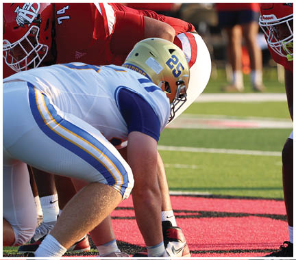 A football player wearing a blue and white uniform. Description generated by AI