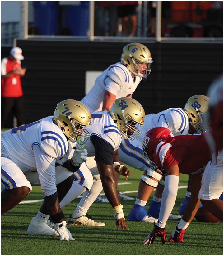 A group of football players wearing black and white uniforms. Description generated by AI
