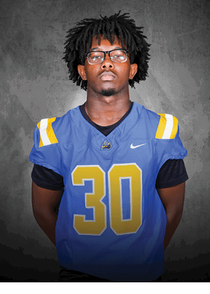 A young man wearing a white and black jersey with the number 14 on it. Description generated by AI