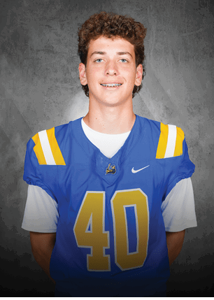 A young man wearing a white and black jersey with the number 14 on it. Description generated by AI