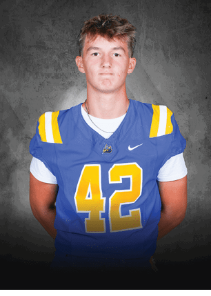 A young man wearing a white and black jersey with the number 14 on it. Description generated by AI