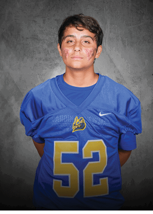 A young man wearing a white and black jersey with the number 14 on it. Description generated by AI