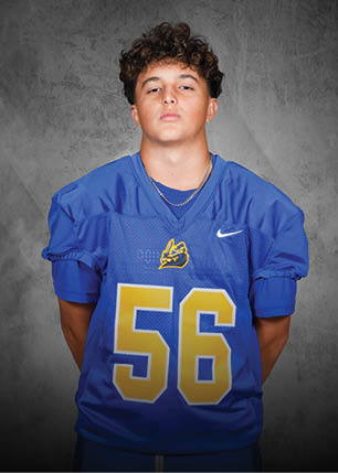 A young man wearing a white and black jersey with the number 14 on it. Description generated by AI