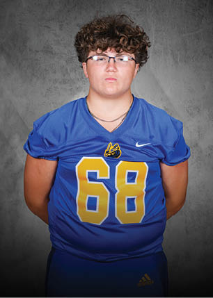A young man wearing a white and black jersey with the number 14 on it. Description generated by AI