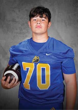 A young man wearing a white and black jersey with the number 14 on it. Description generated by AI