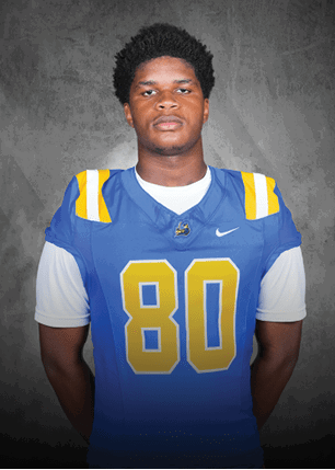 A young man wearing a white and black jersey with the number 14 on it. Description generated by AI