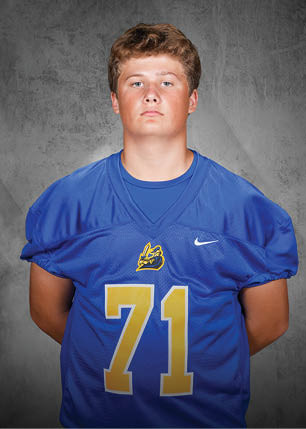 A young man wearing a white and black jersey with the number 14 on it. Description generated by AI