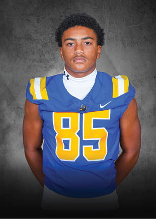 A young man wearing a white and black jersey with the number 14 on it. Description generated by AI