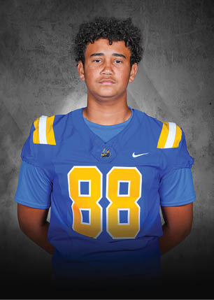 A young man wearing a white and black jersey with the number 14 on it. Description generated by AI