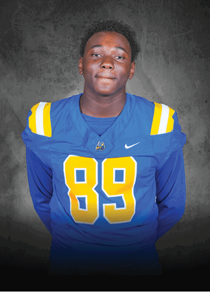 A young man wearing a white and black jersey with the number 14 on it. Description generated by AI