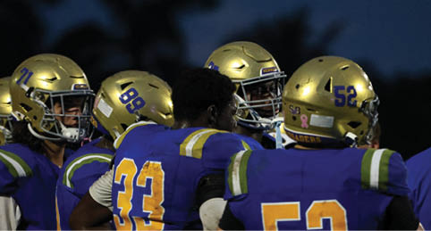 Two men wearing football uniforms are hugging each other on a field. AI generated content