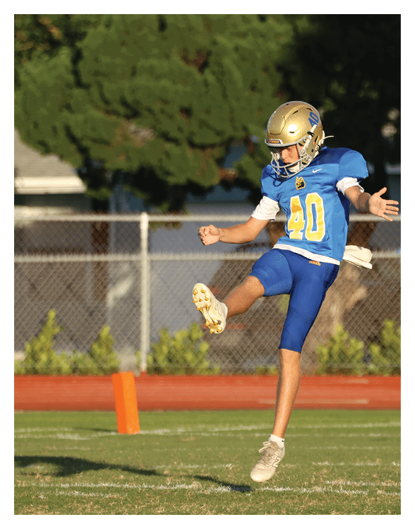 A football player wearing a helmet and white uniform is holding his helmet above his head. AI generated content