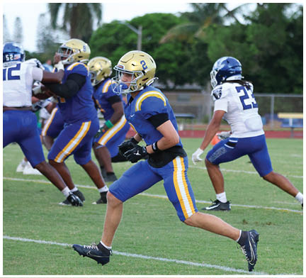 A group of football players huddled together on the field. Description generated by AI