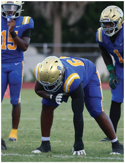 A football player wearing a blue and white uniform. Description generated by AI