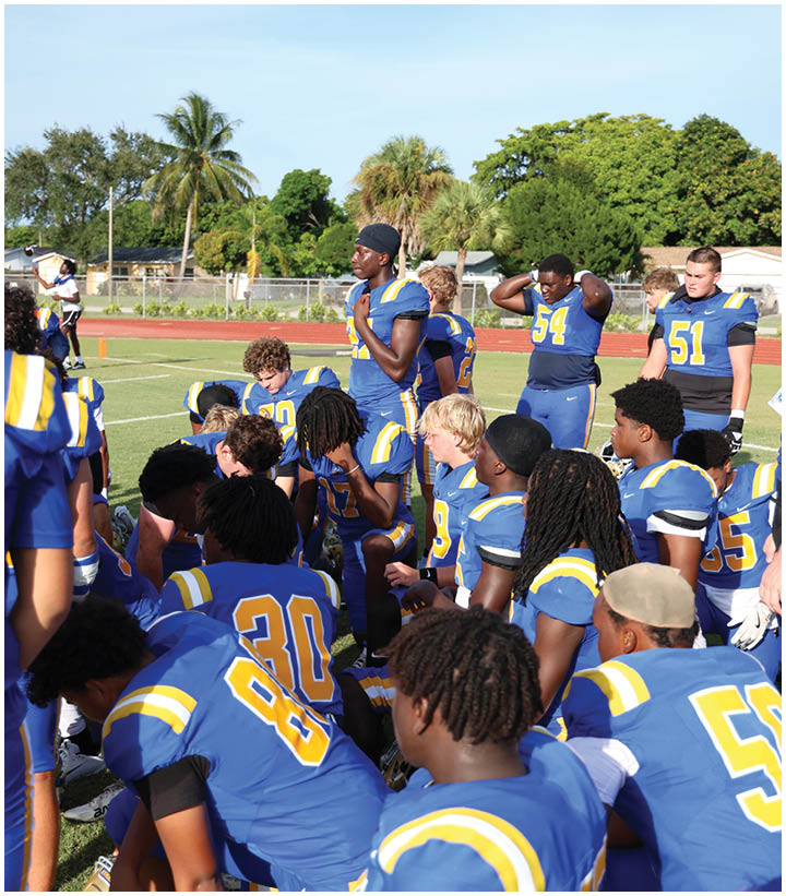 A group of football players wearing black and white uniforms. Description generated by AI