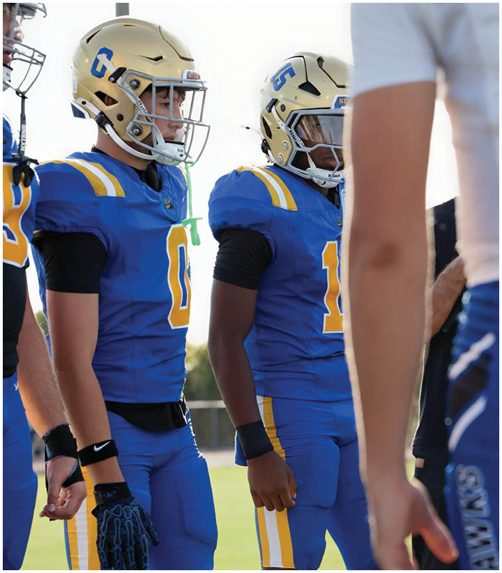 A group of football players wearing black and white uniforms. Description generated by AI