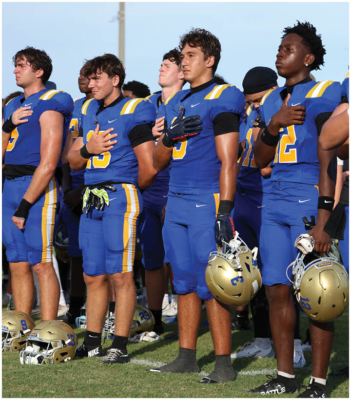 A group of football players wearing black and white uniforms. Description generated by AI