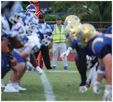 A group of football players huddled together on the field. Description generated by AI