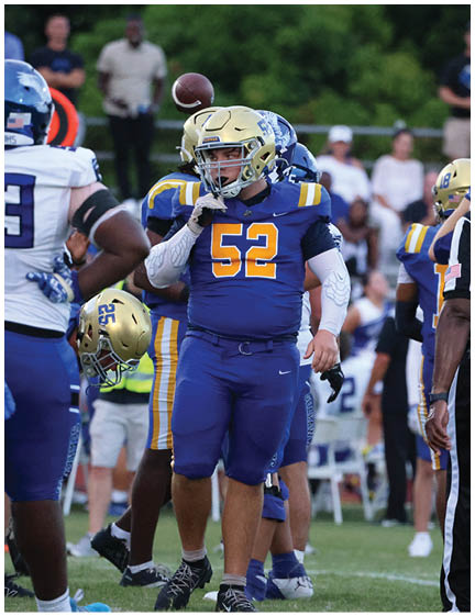 A football player wearing a blue and white uniform. Description generated by AI