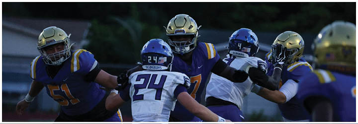 A group of football players on a field. Description generated by AI