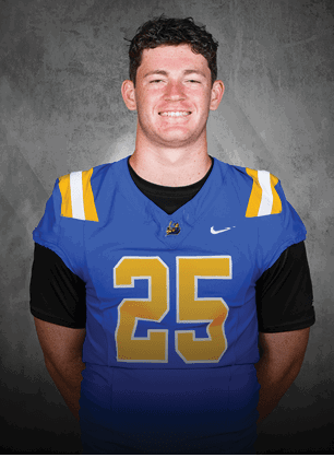 A young man wearing a white and black jersey with the number 14 on it. Description generated by AI