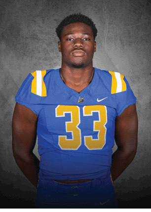 A young man wearing a white and black jersey with the number 14 on it. Description generated by AI