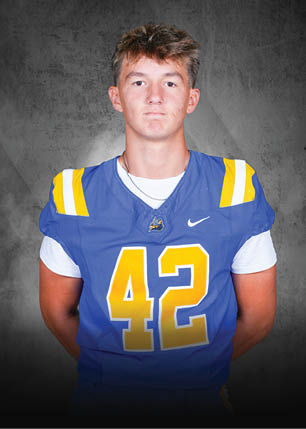 A young man wearing a white and black jersey with the number 14 on it. Description generated by AI
